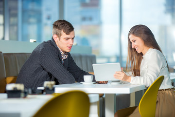 Flirting couple in cafe using digital tablet, selective focus