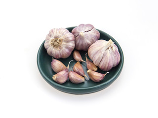 Garlic heads on a green saucer