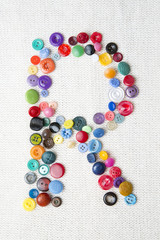 Letter R of the alphabet of buttons of various shapes and colors