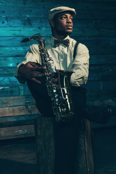African american jazz musician with saxophone in front of old wo