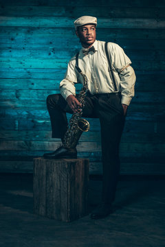 African american jazz musician with saxophone in front of old wo