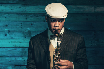 Vintage african american jazz musician with saxophone in front o