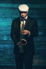 Vintage african american jazz musician with saxophone in front o