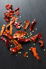 Dried red chilly / chili (ingredient) with seeds on black slate