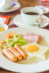 American breakfast fried egg with ham and sausages