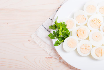 Obraz na płótnie Canvas boiled eggs cut in half on a white plate with parsley on a napki