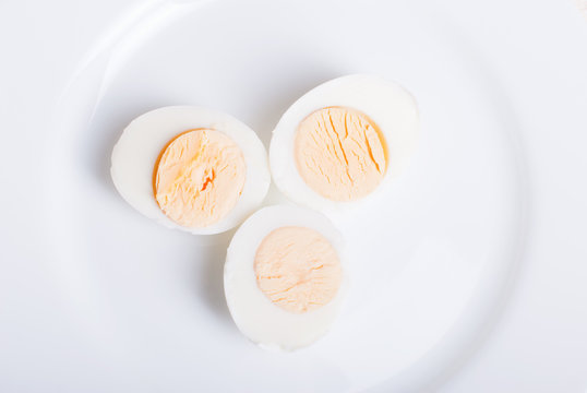 eggs boiled three pieces cut in half on a white plate top view