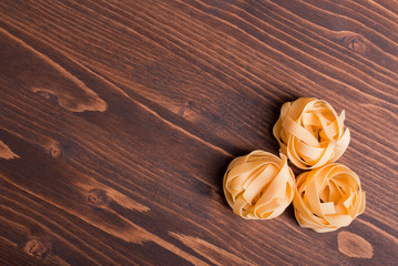 pasta raw three circles on a brown wooden table top view