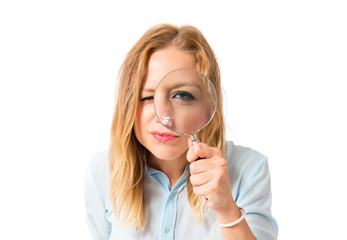 Girl with magnifying glass over white background