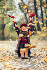 Beautiful blonde throwing leaves in the air