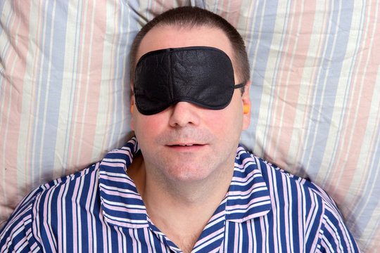 man sleeping with a mask on eyes