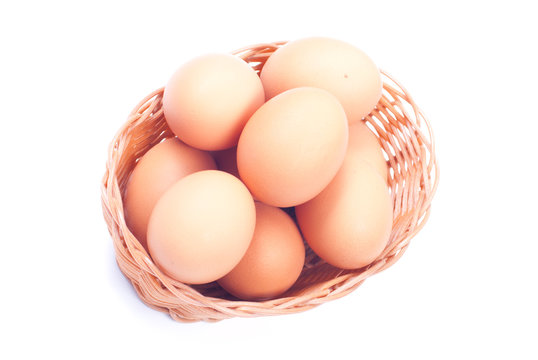 some brown eggs in a wicker basket isolated on white background