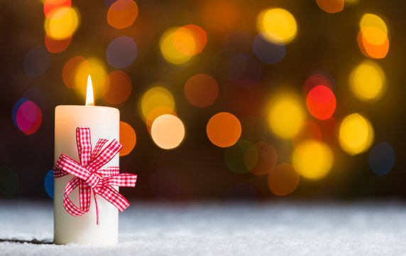 Xmass candle in snow, with bokeh background, copy space