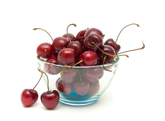cherries in a glass bowl on a white background