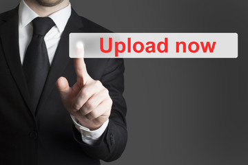 businessman pushing flat button upload now