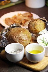 Baked potato on the wooden tray and mix of spices