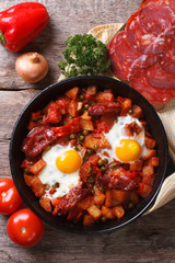 Baked eggs with chorizo and vegetables close up top view