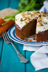 Carrot cake and cloth on table with fresh carrots