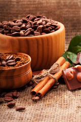 Coffee beans in wooden bowl on burlap tablecloth, rustic style