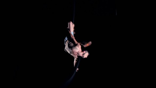 Young man air gymnast on black background