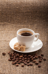 cup of coffee, grains on burlap tablecloth