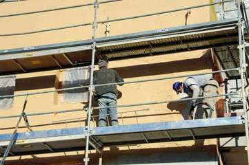 Naklejka premium ouvrier qui pose l'enduit de facade