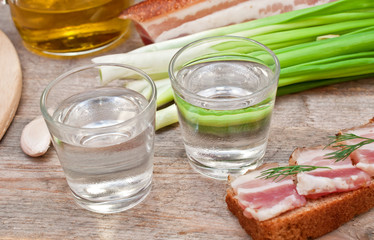 glass of vodka, onions and bacon sandwich