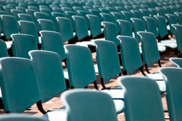 Rows of empty blue chairs for audience