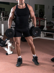 Strong man preparing to lift two heavy dumbbells