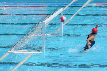 A water polo goalkeeper misses the ball going into the net of th