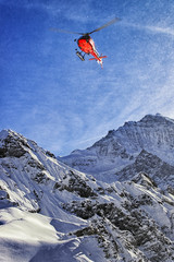 Naklejka na ściany i meble Red helicopter at swiss alps sky near Jungfrau mountain