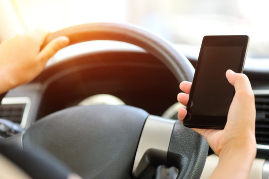 woman driver hands use cellphone driving a car