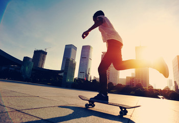 woman skateboarder skateboarding at sunrise city 