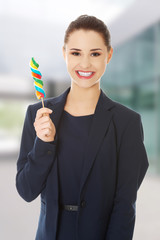 Beautiful businesswoman with lollipop