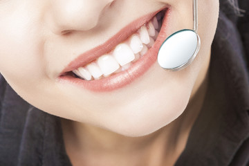Caucasian Woman White Teeth with Dentist Mouth Mirror.