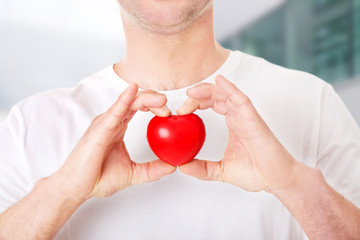 Young man holding a red heart