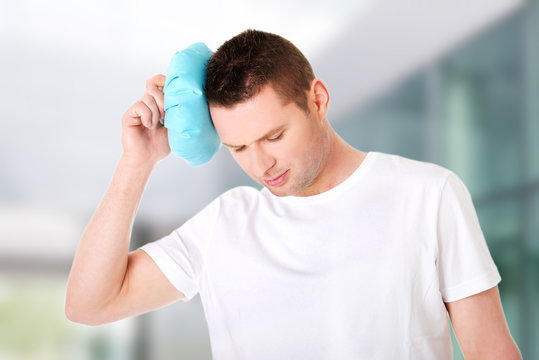 Man with ice bag for headaches