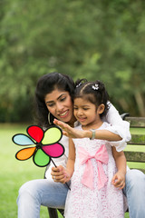 Happy Indian mother and daughter playing in the park. Lifestyle
