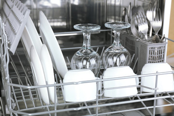 Fototapeta na wymiar Open dishwasher with clean utensils in it