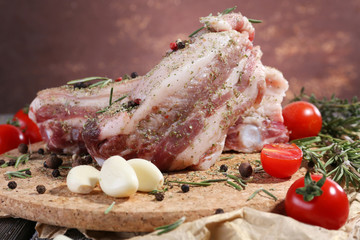 raw bacon with spices and tomatoes on wooden table