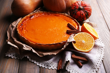 Homemade pumpkin pie on napkin, on wooden background