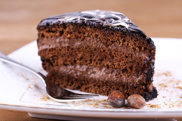 Delicious chocolate cake on plate on table close-up