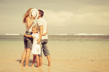 Happy family standing on the beach at the day time