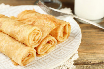 Plate of delicious pancakes with berry jam and glass of milk