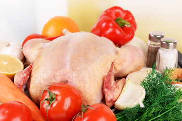 Raw chicken with vegetables on table, close-up