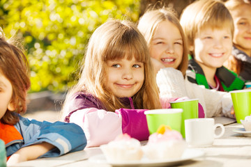 Fototapeta premium Happy children with tea cups sitting outside
