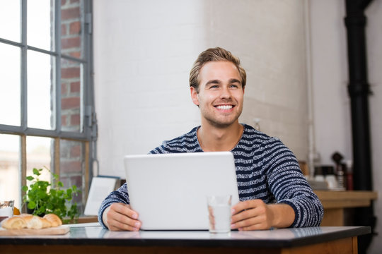 glücklich lächelnder mann arbeitet am notebook