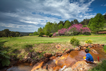 young boy playing at beautiful golf course