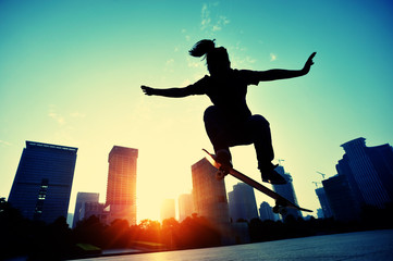 woman skateboarder skateboarding at sunrise city