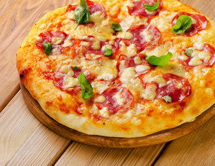 Fresh homemade salami pizza on a wooden  board